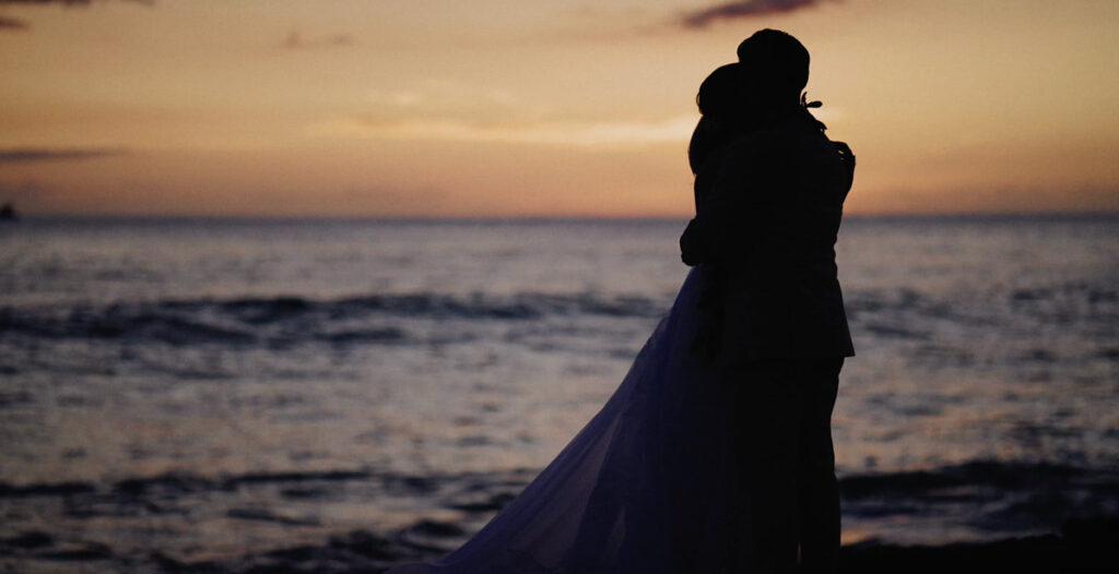 A wedding couple on the rocks near the Four Seasons Resort on Oahu