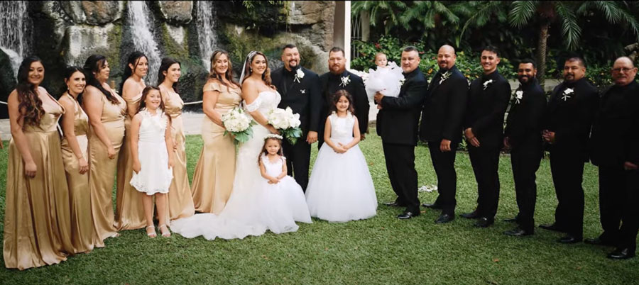 Wedding party posing in front of the waterfall at Akala Chapel